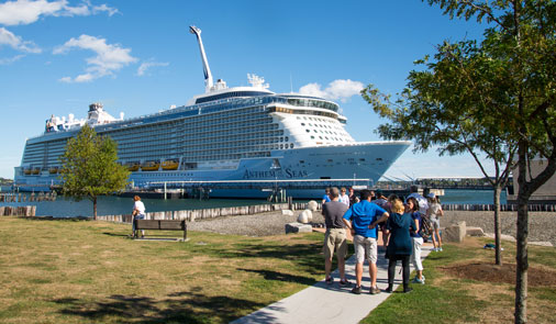 People gather in front of a cruise ship docked along the Portland waterfront.