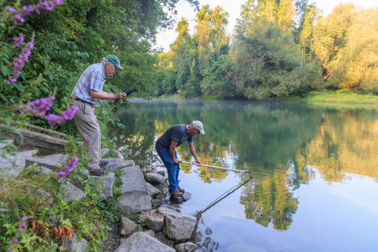 Two men collecting water quality samples from a river.